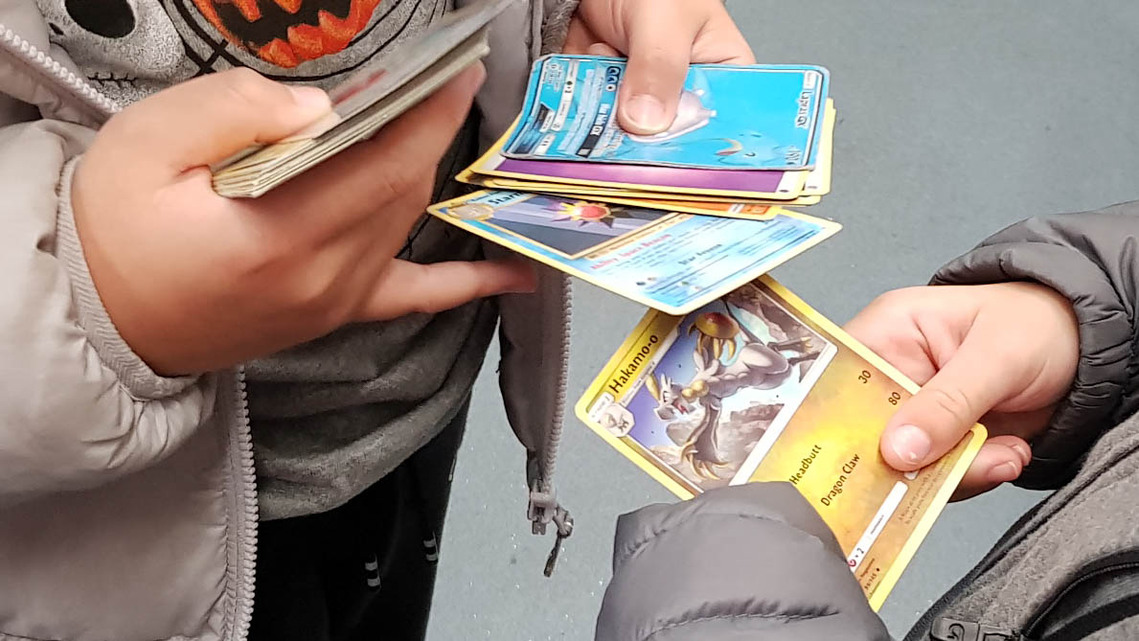 Hands swapping Pokemon Cards