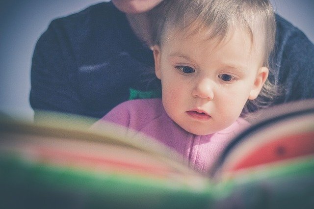 Toddler looking at an open book
